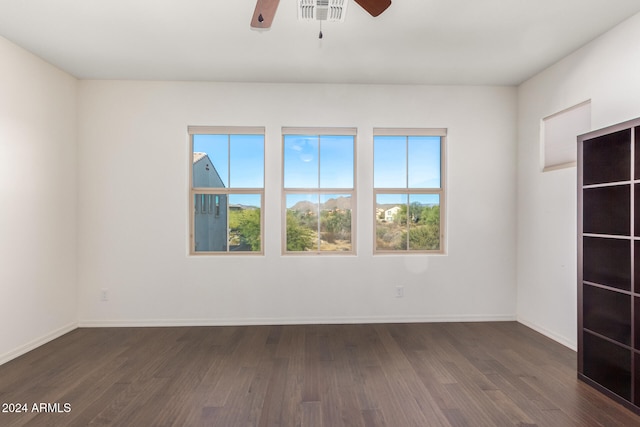 empty room with ceiling fan and dark hardwood / wood-style flooring