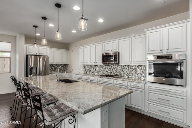 kitchen with appliances with stainless steel finishes, a sink, white cabinetry, recessed lighting, and tasteful backsplash