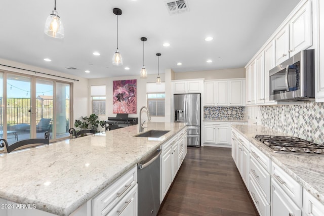 kitchen featuring stainless steel appliances, a sink, recessed lighting, healthy amount of natural light, and white cabinets