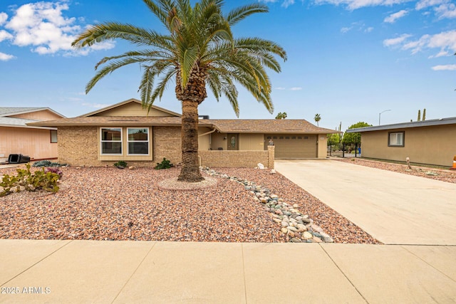 ranch-style home with a garage, brick siding, and concrete driveway