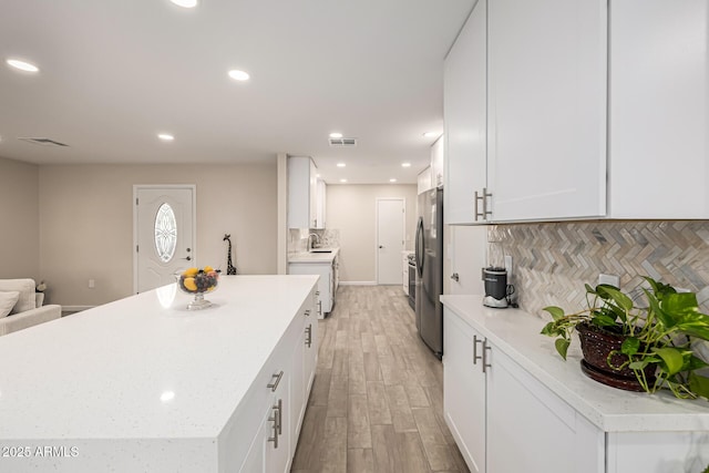 kitchen with white cabinetry, recessed lighting, visible vents, and light wood finished floors