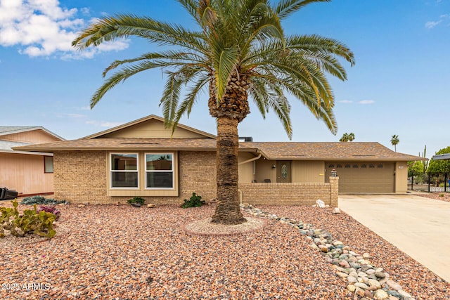 single story home featuring a garage, fence, brick siding, and driveway