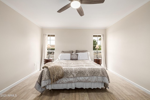 bedroom featuring light wood-type flooring, multiple windows, and baseboards