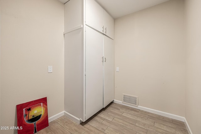 interior space with visible vents, light wood-type flooring, and baseboards