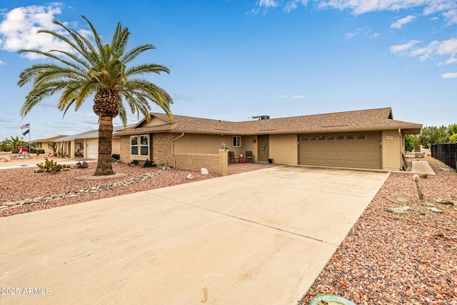 single story home with concrete driveway, a garage, and fence