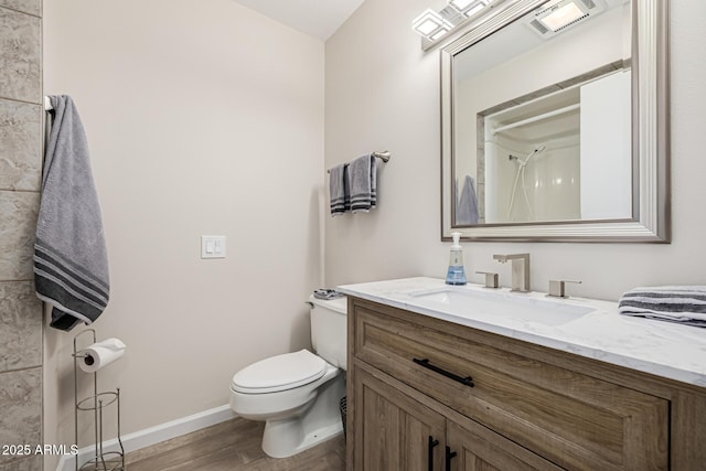 bathroom with visible vents, toilet, wood finished floors, baseboards, and vanity