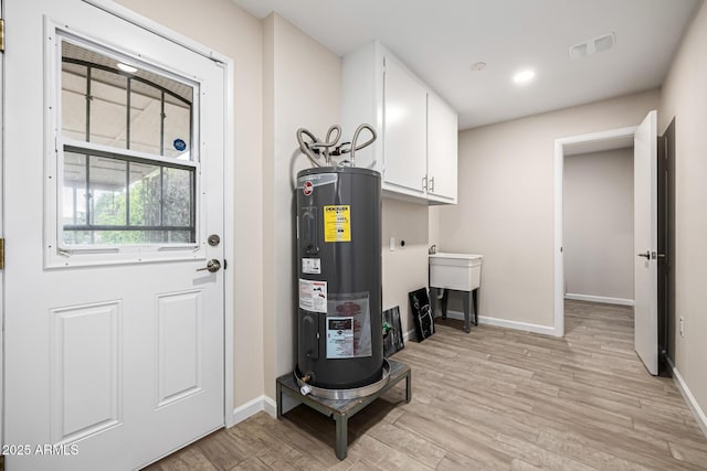 utility room featuring visible vents and electric water heater