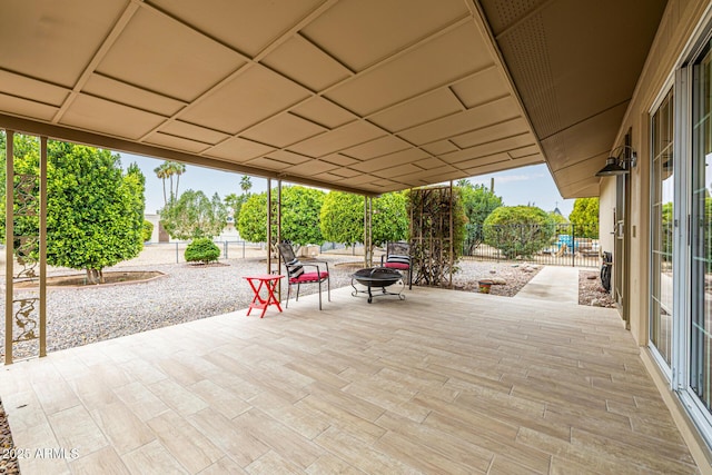 view of patio with a fire pit and fence