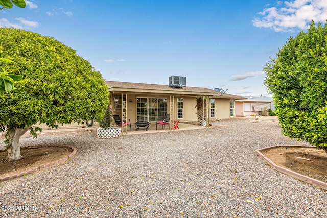 back of house with a patio area, central air condition unit, and an outdoor fire pit