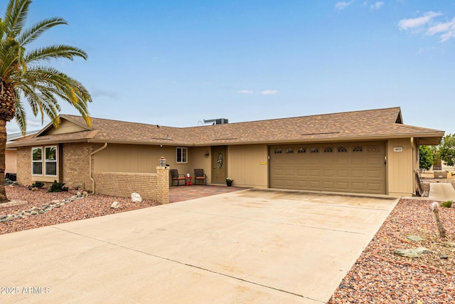 single story home featuring an attached garage, driveway, and roof with shingles