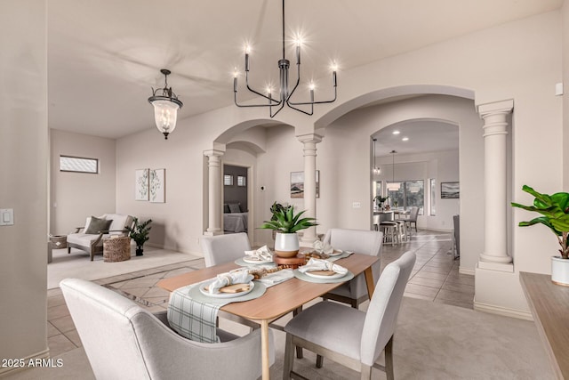 dining room with light tile patterned flooring, ornate columns, and a chandelier