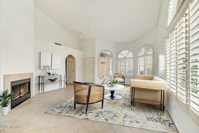 sitting room featuring light tile patterned floors and high vaulted ceiling