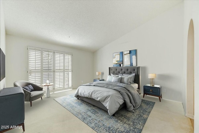 carpeted bedroom with lofted ceiling and a textured ceiling