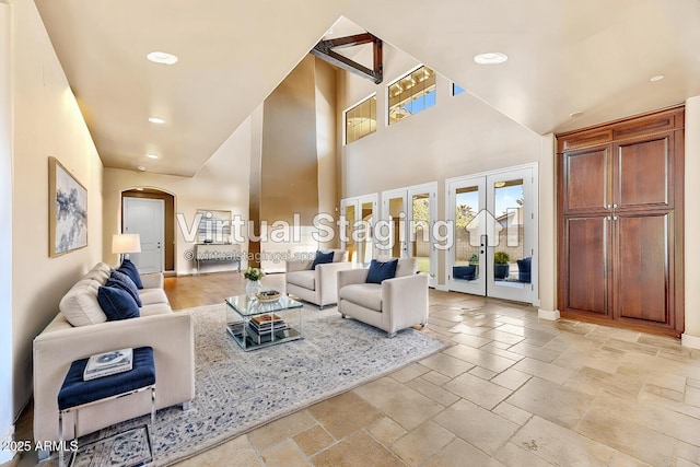 living room with a towering ceiling and french doors