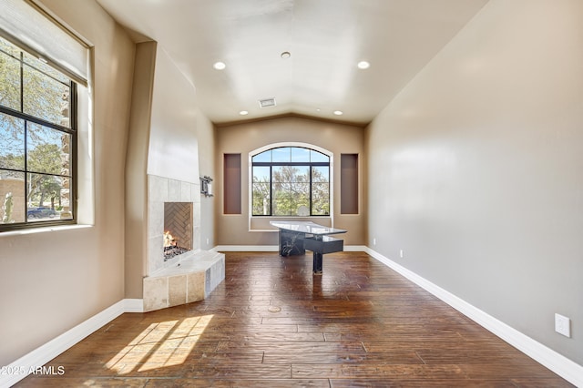 interior space with hardwood / wood-style flooring, vaulted ceiling, and a fireplace