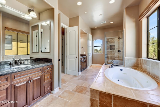 bathroom featuring vanity and shower with separate bathtub