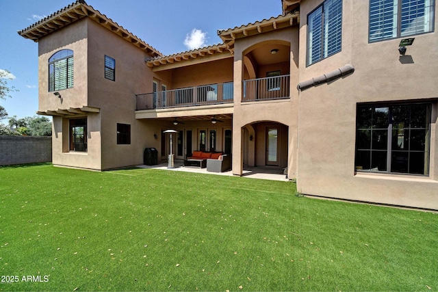 back of property with a patio area, an outdoor hangout area, ceiling fan, and a lawn
