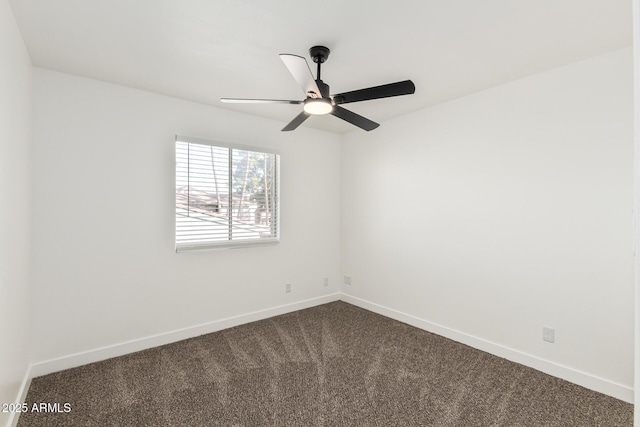 carpeted spare room featuring baseboards and a ceiling fan