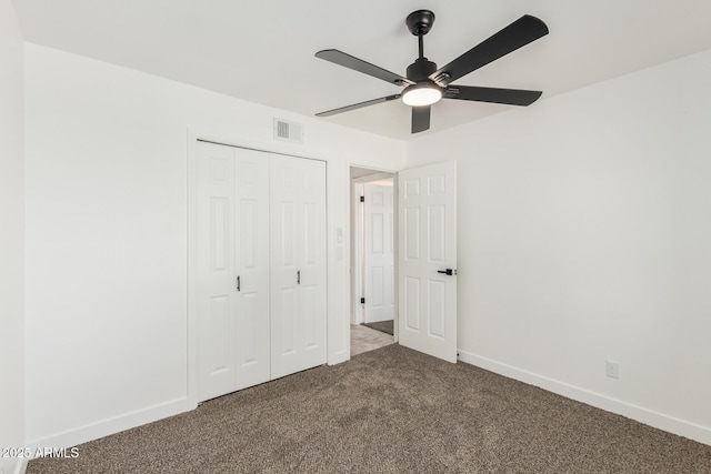 unfurnished bedroom with baseboards, carpet, visible vents, and a closet