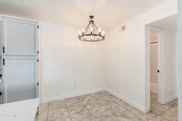 unfurnished dining area featuring baseboards, visible vents, and a notable chandelier