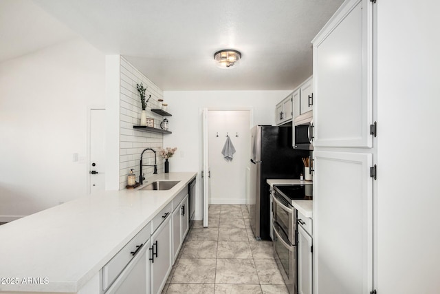 kitchen with open shelves, light countertops, appliances with stainless steel finishes, white cabinets, and a sink