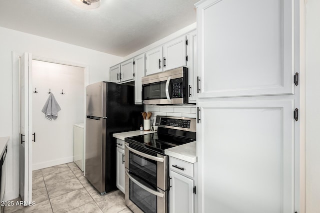 kitchen with white cabinets, baseboards, stainless steel appliances, and light countertops