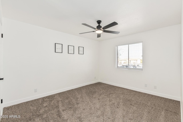 carpeted spare room with ceiling fan and baseboards