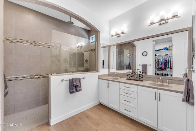 5637 S Parrish, Mesa, AZ 85212 - bathroom with a walk in shower, double vanity, a walk in closet, and wood finished floors