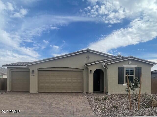 12389 W Marguerite Ave, Avondale, AZ 85323 - view of front of house featuring a garage, decorative driveway, and stucco siding