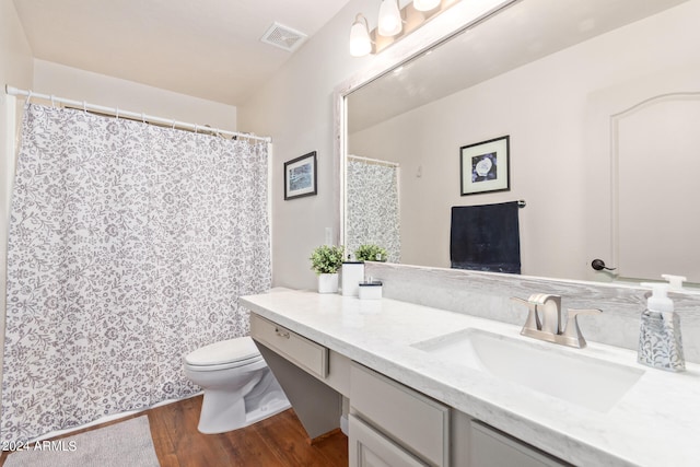 bathroom with toilet, hardwood / wood-style flooring, and vanity