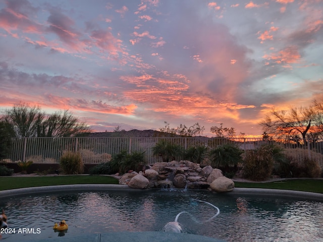 pool at dusk with pool water feature