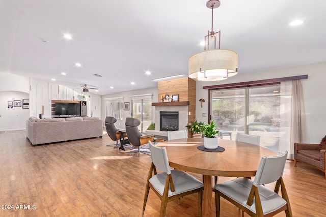 dining area featuring light wood-type flooring and a large fireplace