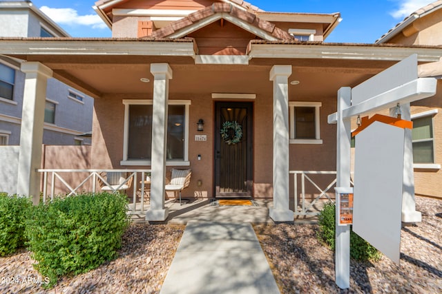 view of exterior entry with covered porch