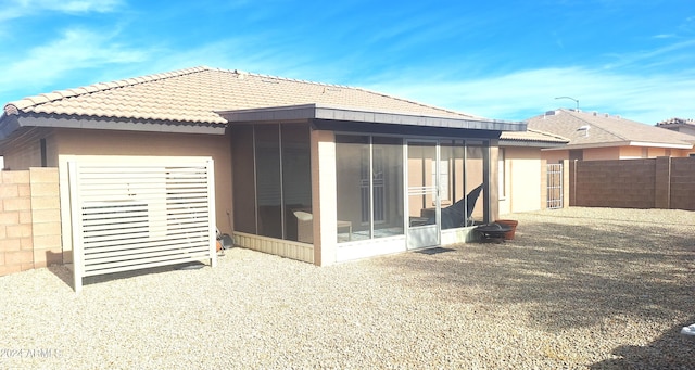 rear view of property featuring a sunroom