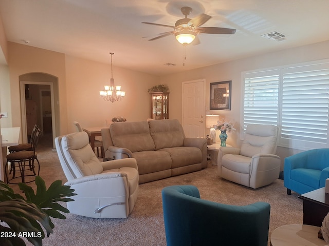 carpeted living room featuring ceiling fan with notable chandelier