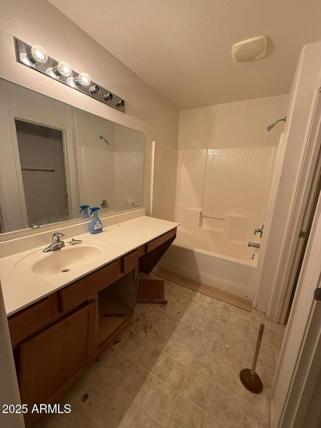 bathroom featuring a textured ceiling, vanity, and washtub / shower combination