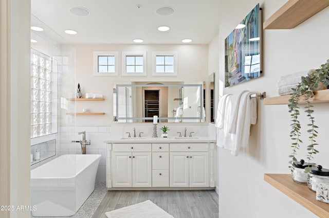 bathroom with hardwood / wood-style flooring, vanity, tile walls, and a bathtub