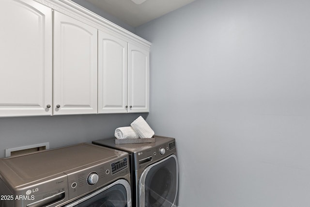 laundry area featuring cabinets and washing machine and dryer