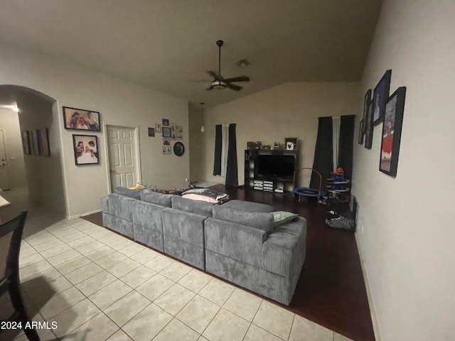 living room featuring ceiling fan, light tile patterned floors, and lofted ceiling