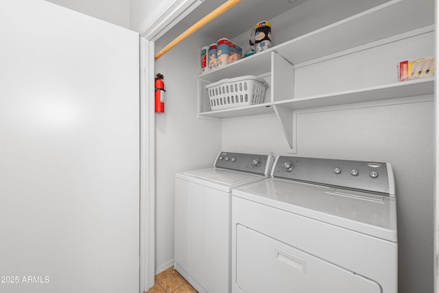 laundry room with laundry area, light tile patterned floors, and washing machine and clothes dryer