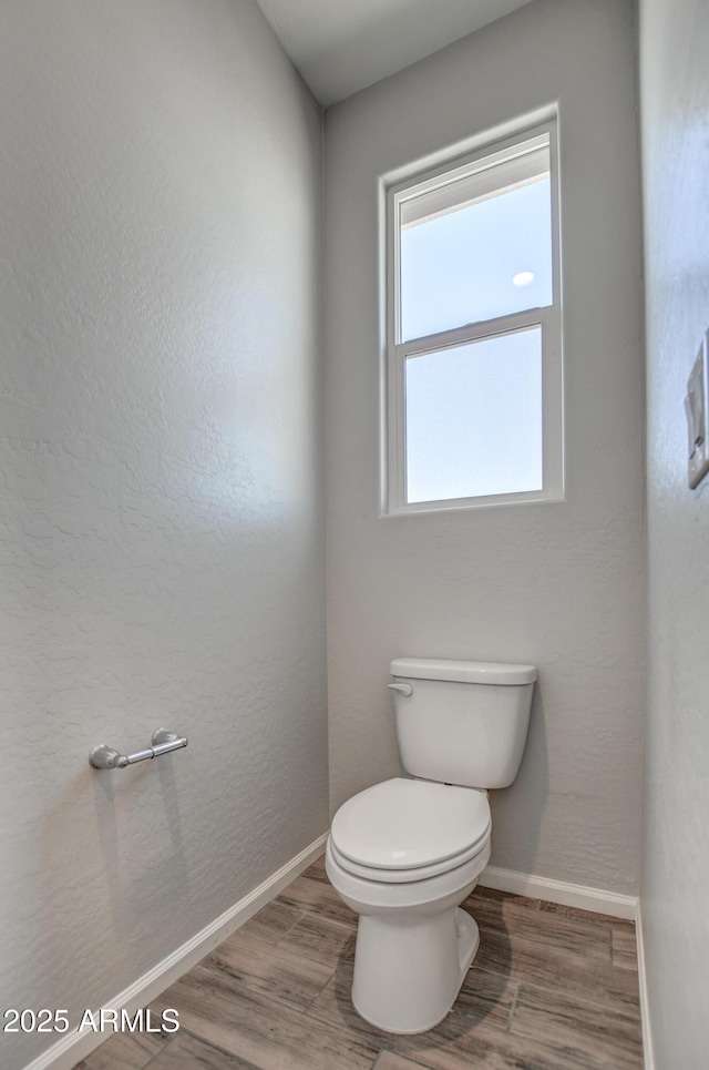 bathroom with toilet and wood-type flooring