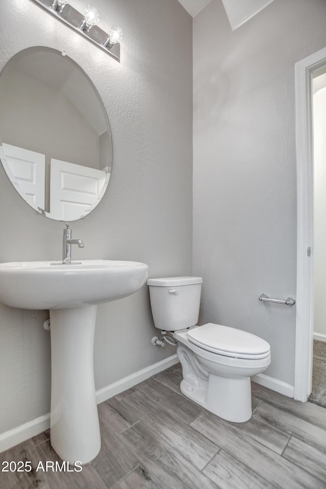 bathroom featuring hardwood / wood-style flooring, sink, and toilet