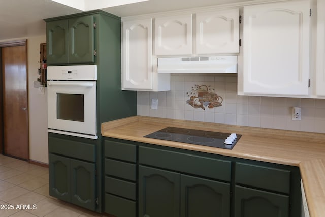 kitchen featuring white oven, white cabinets, light countertops, and under cabinet range hood