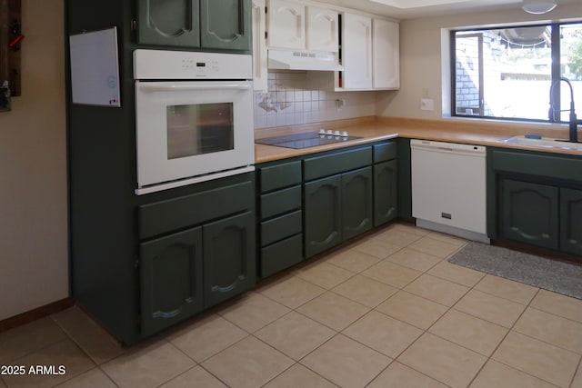 kitchen with light countertops, white cabinetry, a sink, white appliances, and under cabinet range hood