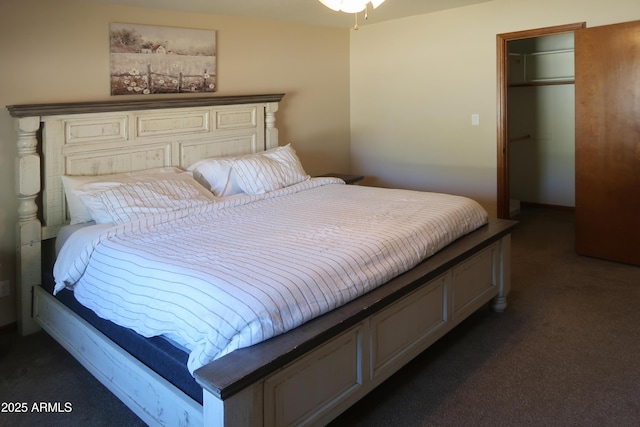 bedroom with a spacious closet, a closet, and dark carpet