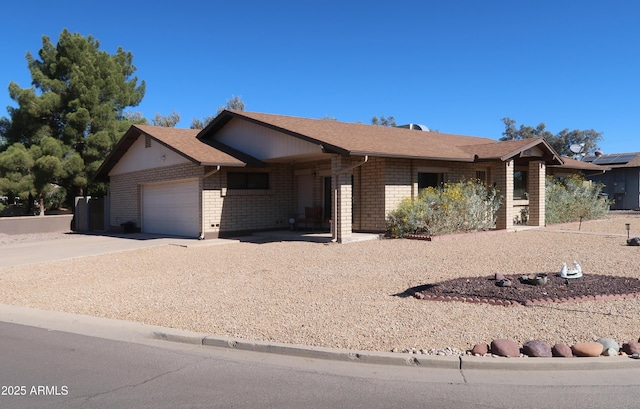 single story home with a garage, driveway, brick siding, and roof with shingles