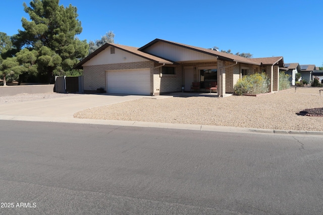 view of front of house featuring an attached garage, concrete driveway, and brick siding