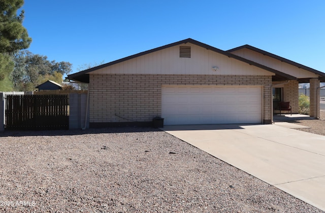 view of front of house with an attached garage, driveway, and brick siding