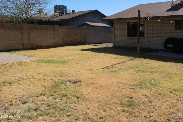 view of yard with fence and central AC unit