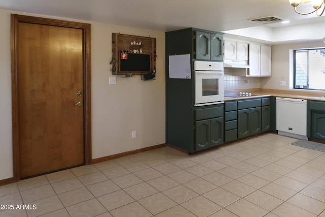 kitchen with light countertops, visible vents, white appliances, green cabinetry, and under cabinet range hood